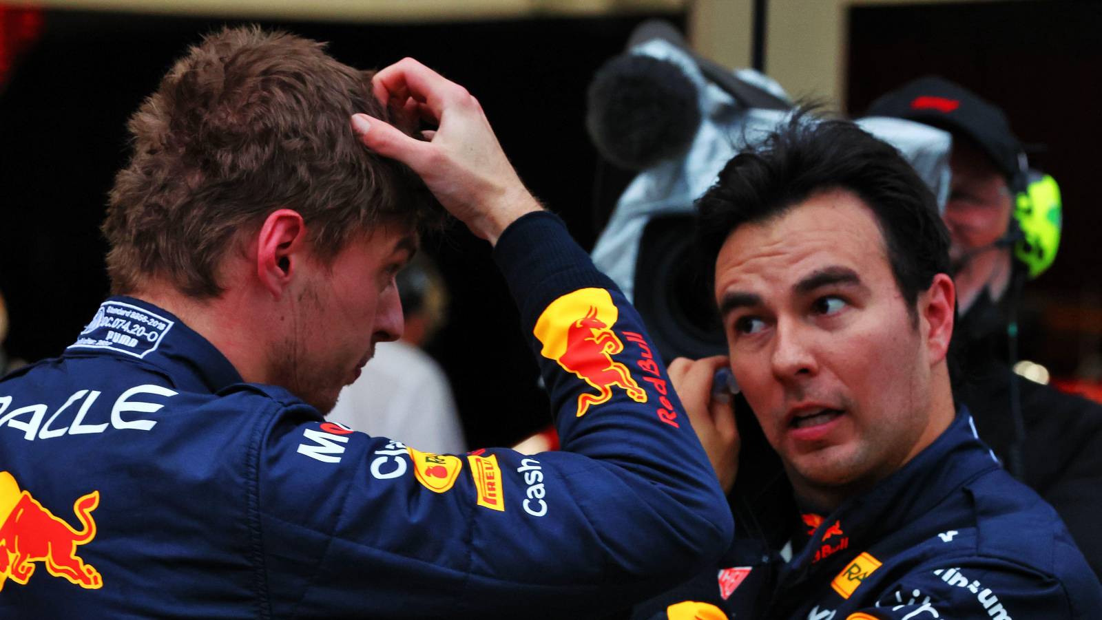 Max Verstappen scratching head next to Sergio Perez. Suzuka October 2022.