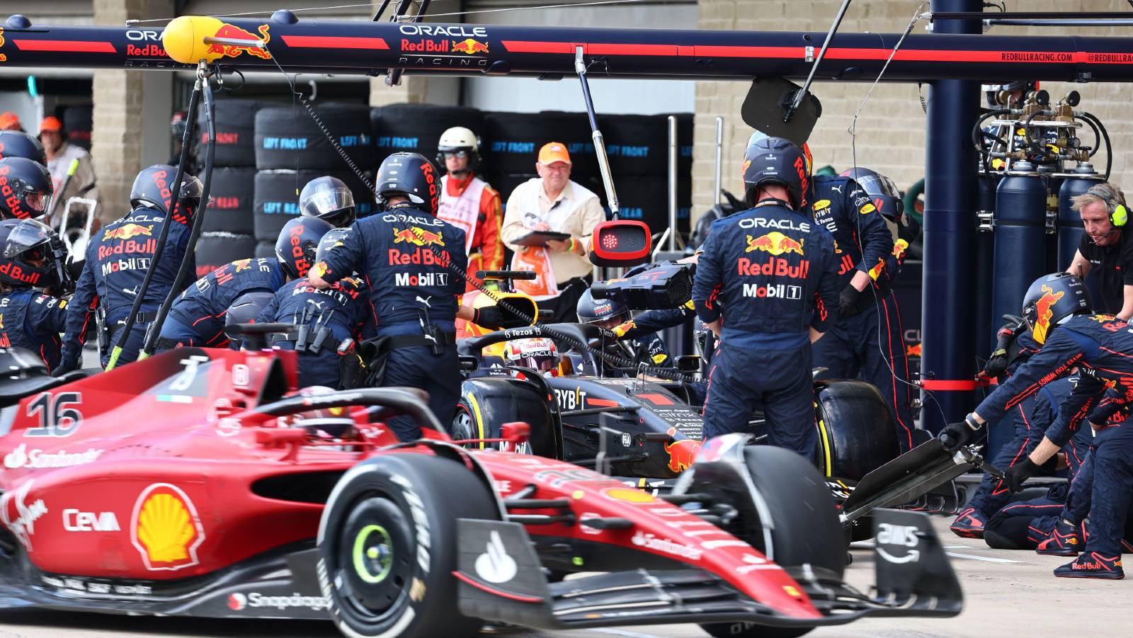 Charles Leclerc passes Max Verstappen during a botched Red Bull pit-stop. Austin October 2022.