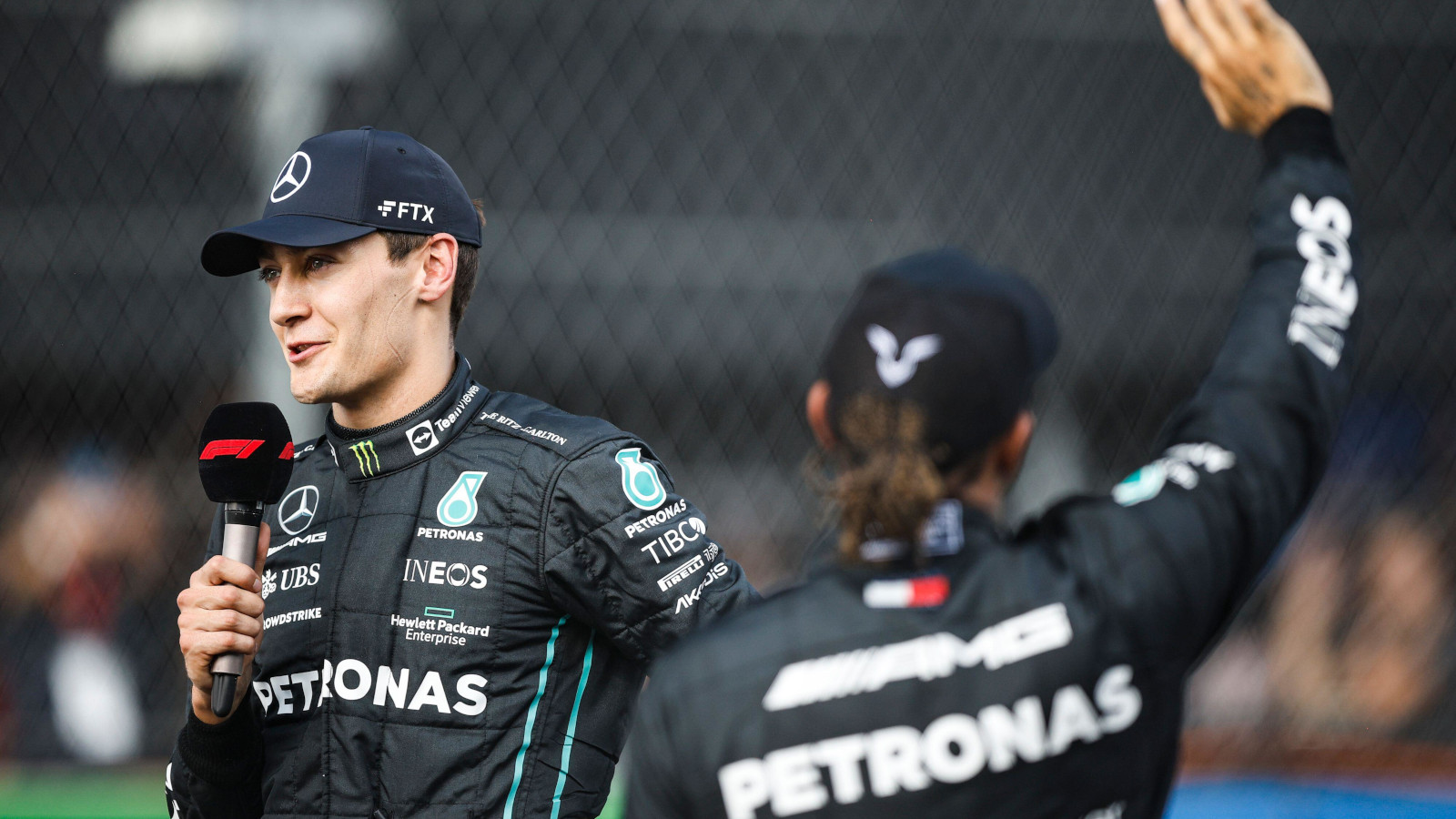 George Russell at the mic Lewis Hamilton waving. Mexico October 2022