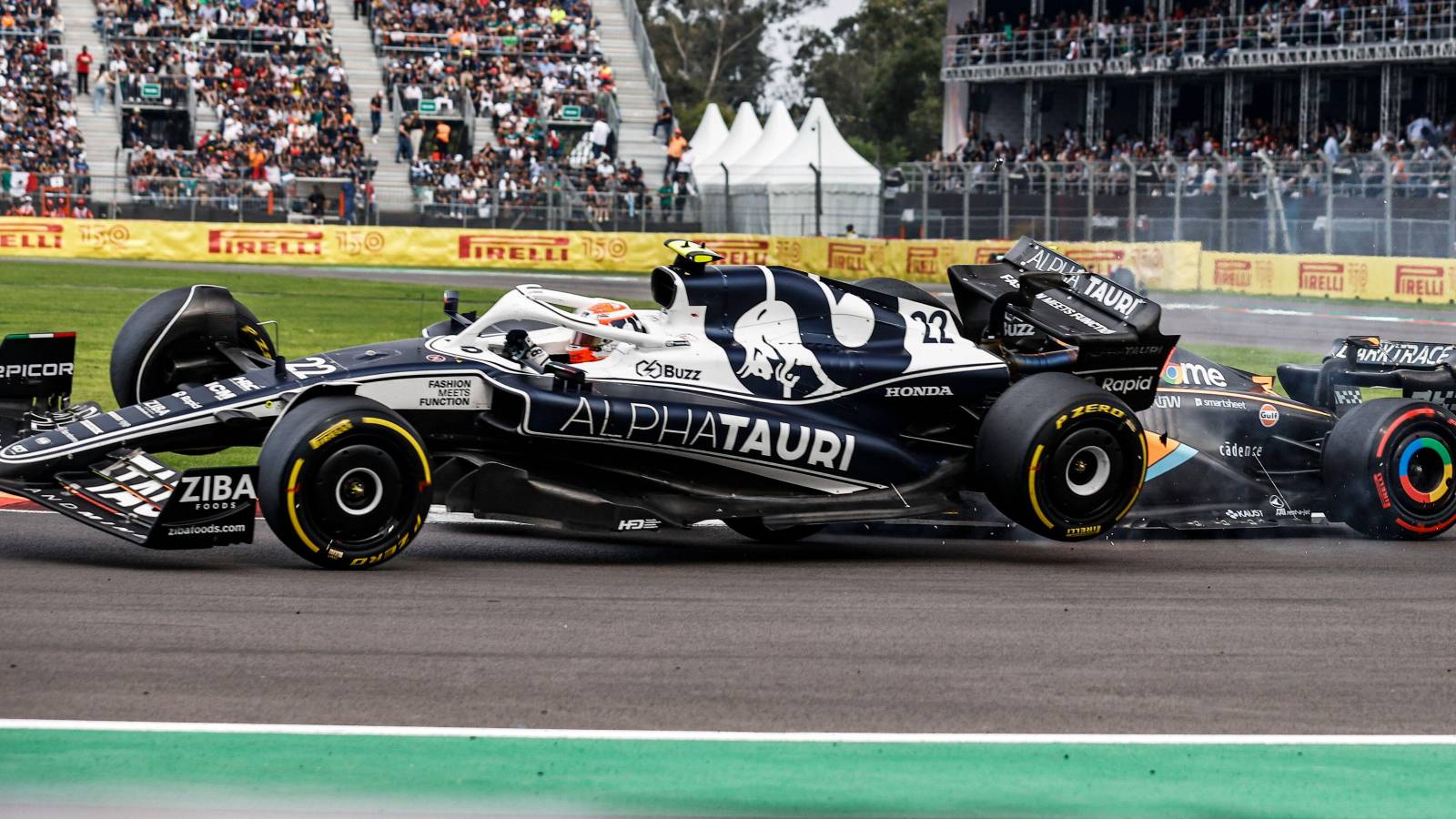 Daniel Ricciardo, McLaren, sends Yuki Tsunoda, AlphaTauri, off the ground. Mexico, October 2022.