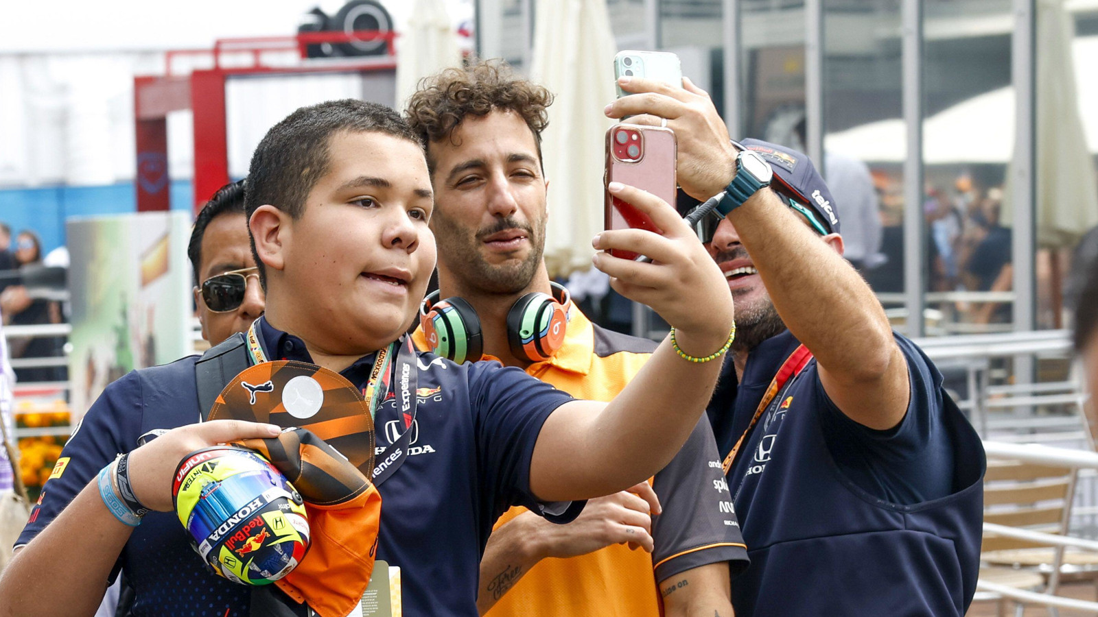 Fans take a photo with Daniel Ricciardo in the paddock. Mexico October 2022