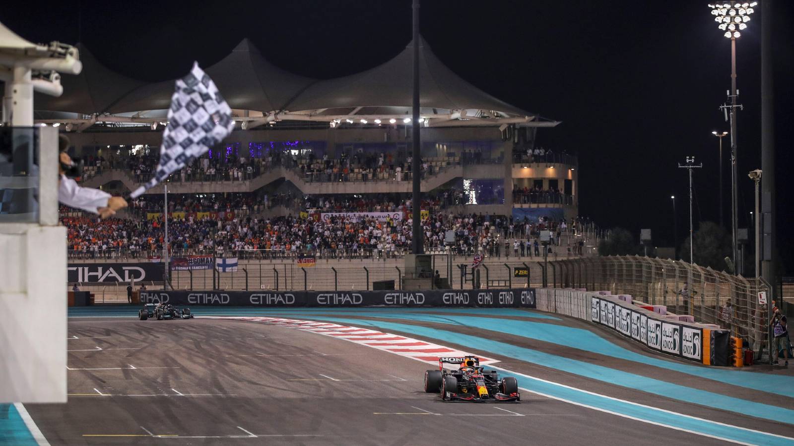 Max Verstappen takes the chequered flag in the Abu Dhabi GP. Yas Marina December 2021.