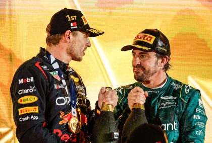 马克斯·维斯塔彭和费尔南多·阿隆索在领奖台上拿着香槟微笑。2023年3月巴林