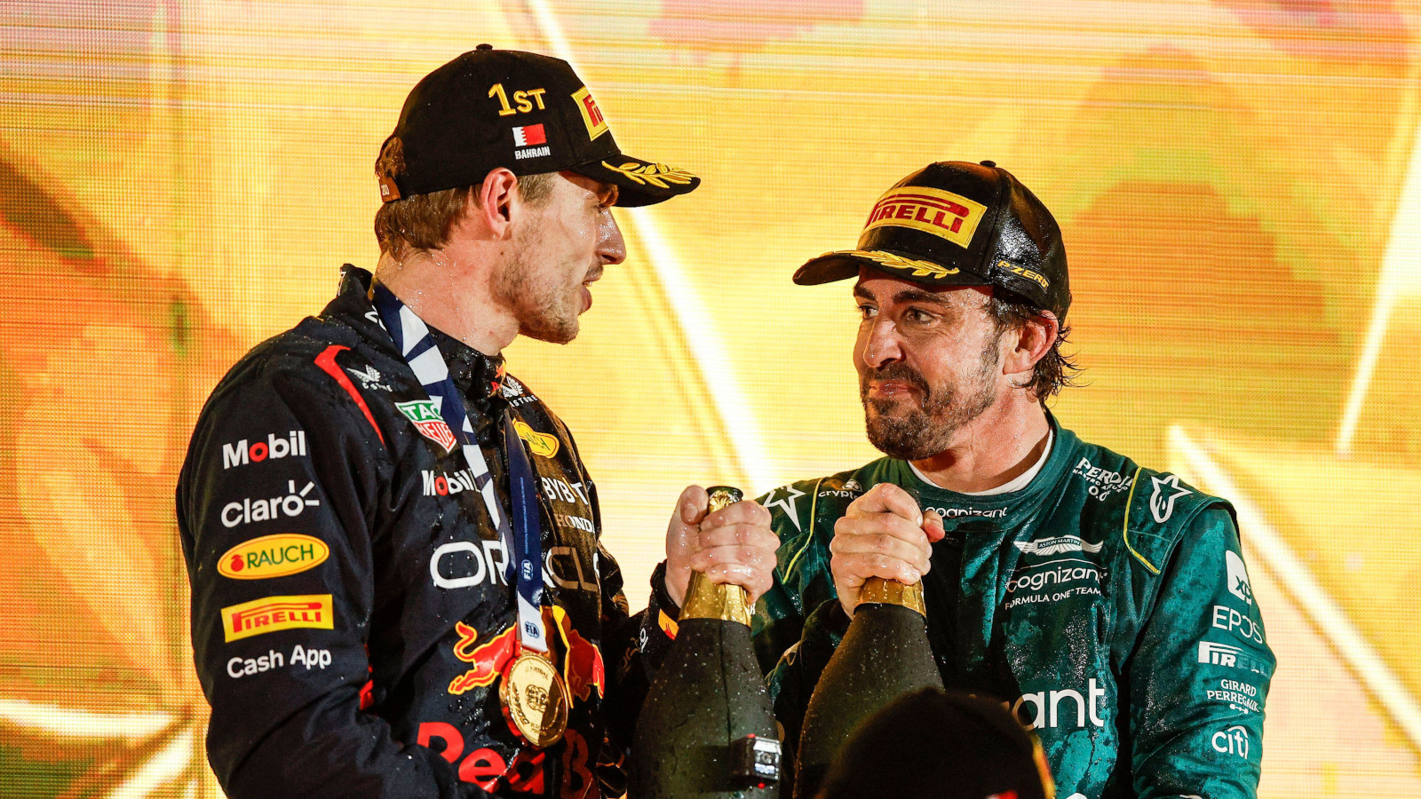 马克斯·维斯塔潘和费尔南多·阿隆索拿着香槟在领奖台上微笑。巴林2023年3月