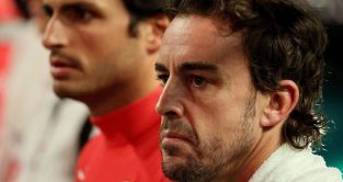 Aston Martin driver Fernando Alonso and Carlos Sainz look on.
