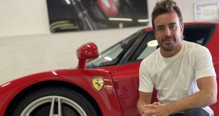 Fernando Alonso poses with the Ferrari Enzo road car he has put up for auction. May, 2023.
