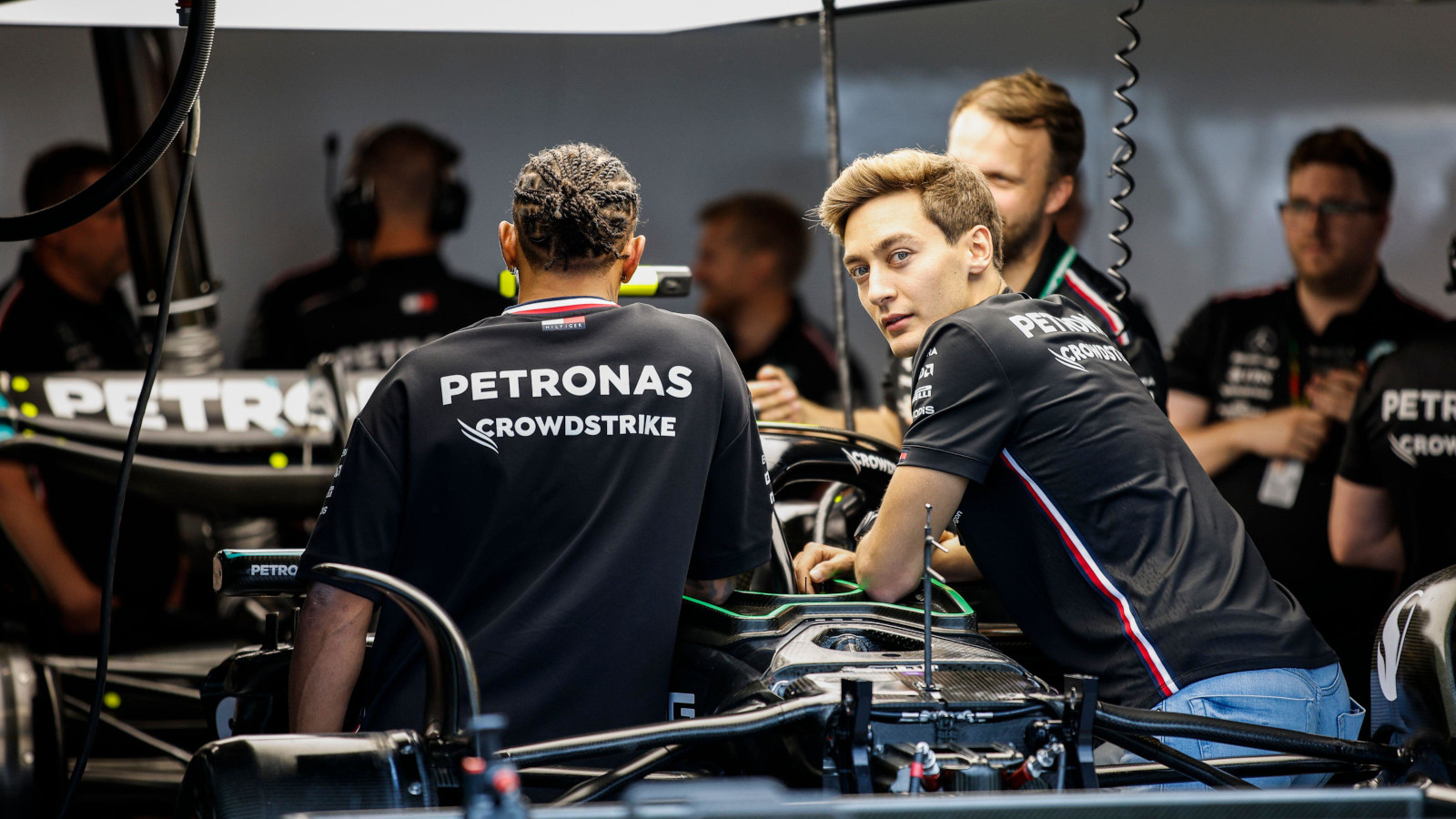 Mercedes driver George Russell looking at the W14 with Lewis Hamilton. Canada June 2023