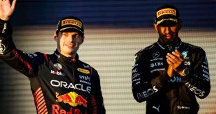 Max Verstappen (Red Bull) waves from the podium as Lewis Hamilton (Mercedes) looks on at the Australian Grand Prix. Melbourne, April 2023.