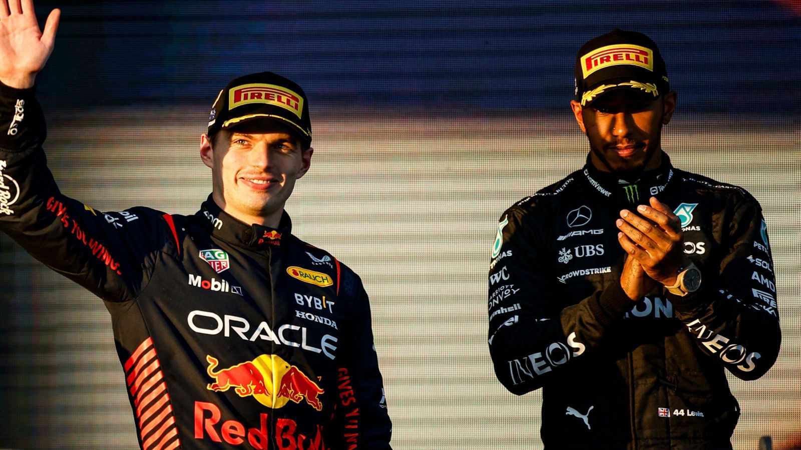 Max Verstappen (Red Bull) waves from the podium as Lewis Hamilton (Mercedes) looks on at the Australian Grand Prix. Melbourne, April 2023.