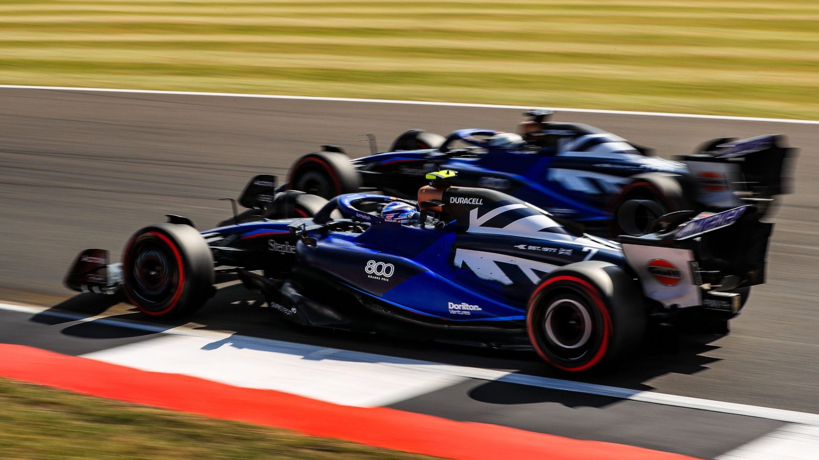 Logan Sargeant and Alex Albon running side by side. Britain July 2023