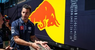 Daniel Ricciardo gesturing toward the Red Bull garage of Max Verstappen. Hungary July 2023