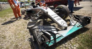 Marshals recover Lewis Hamilton's crashed car after Nico Rosberg collision