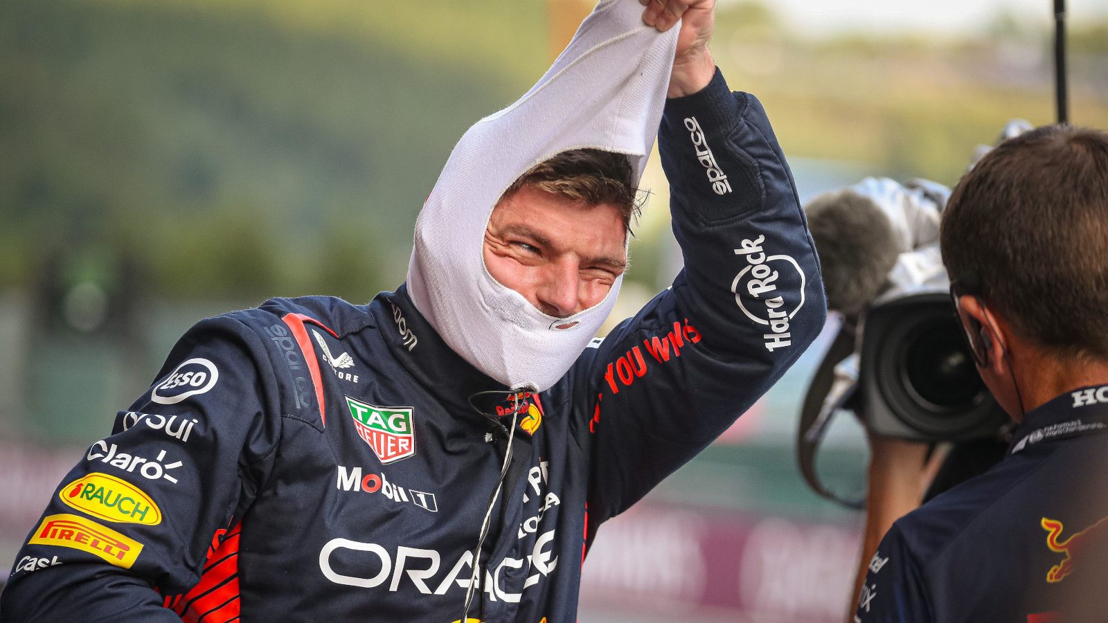 Max Verstappen smiling as he pulls off his fireproofs. Belgium July 2023