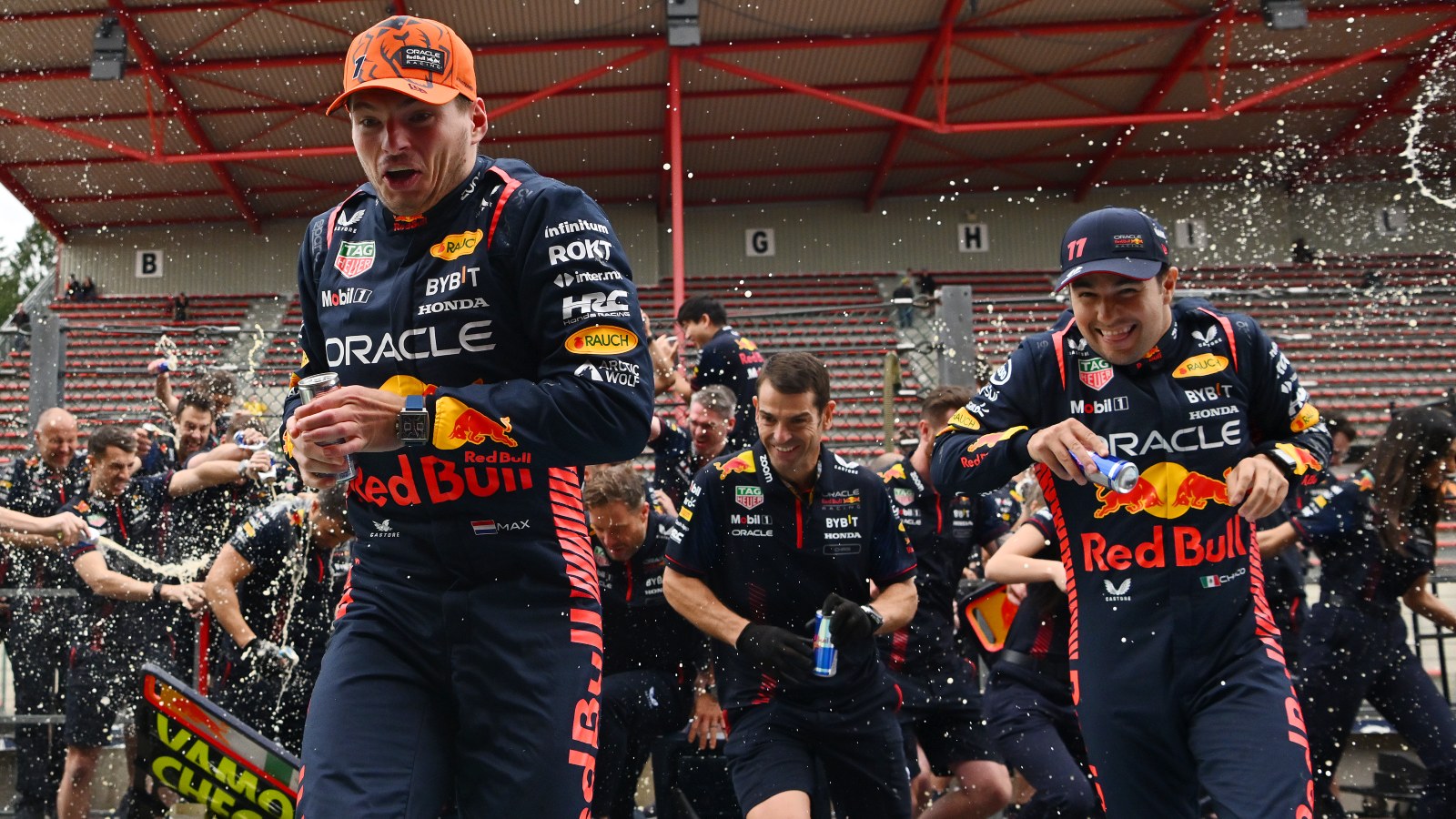 Max Verstappen and Sergio Perez run for cover from Red Bull spray.