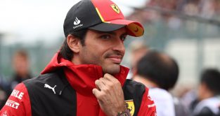 2023 Belgian Grand Prix: Ferrari's Carlos Sainz adjusts his jacket against the windy conditions at Spa-Francorchamps.