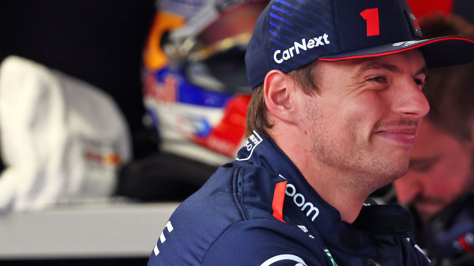 卫冕世界冠军马克斯Verstappen grinning in the Red Bull garage.