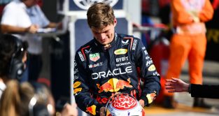 Red Bull driver Max Verstappen smiling as he puts his helmet down after another good session.