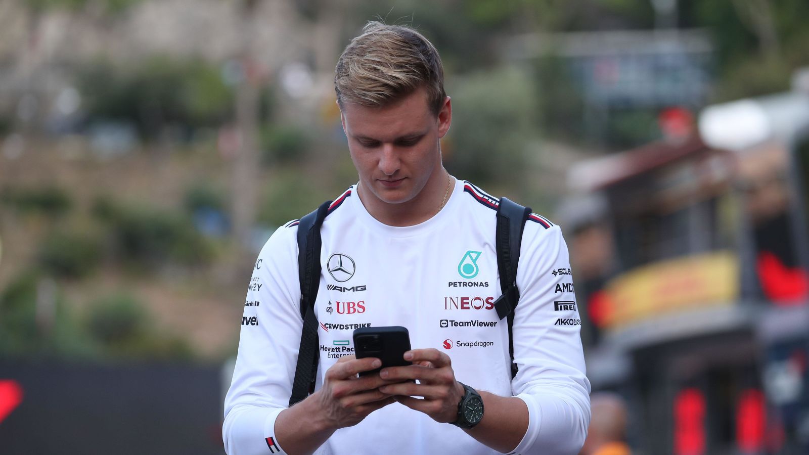 Mercedes reserve driver Mick Schumacher checks his messages at the 2023 Monaco Grand Prix.