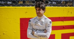 Aston Martin Lance Stroll with a quirky look on his face and his arms crossed.