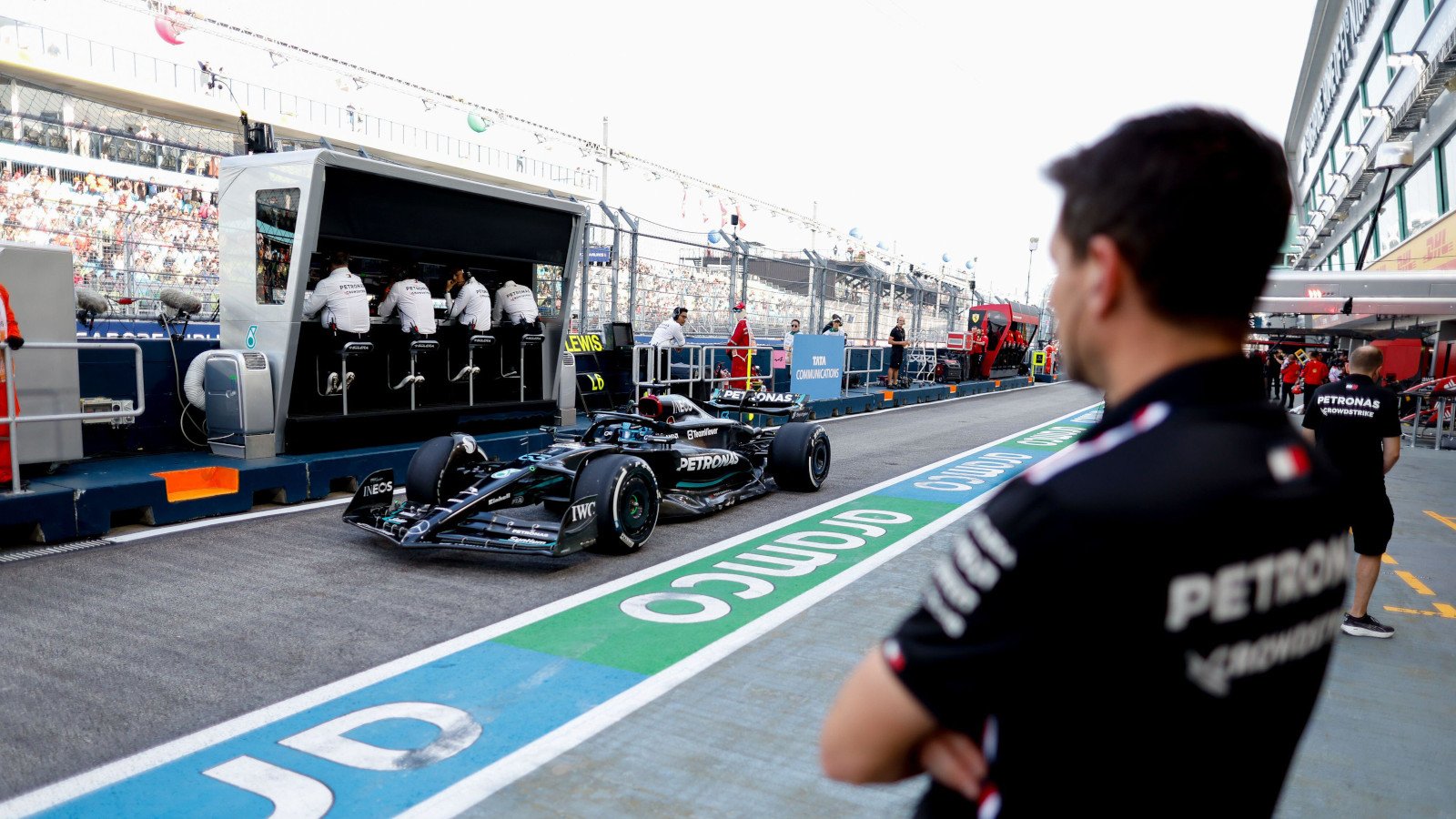 Mercedes driver George Russell drives down the pit lane and past the Mercedes gantry.