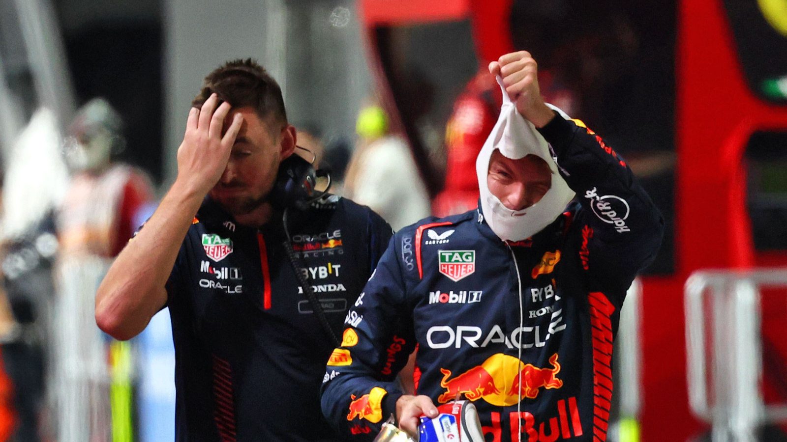 Max Verstappen pulls off his fireproofs after exiting qualifying in Singapore.
