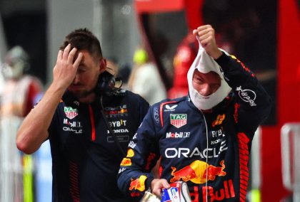 Max Verstappen pulls off his fireproofs after exiting qualifying in Singapore.