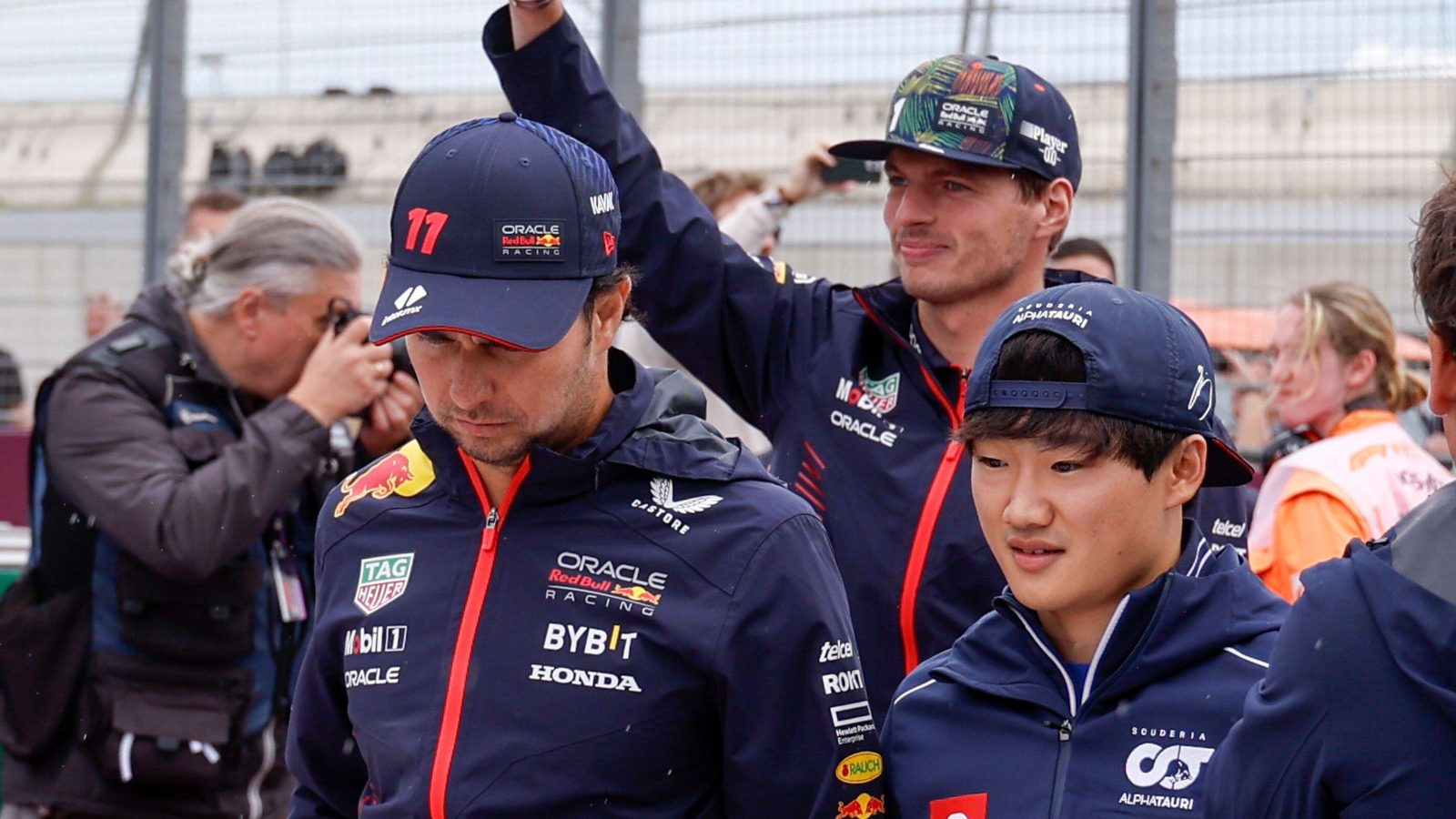 AlphaTauri driver Yuki Tsunoda walking with Sergio Perez ahead of the Dutch GP, Max Verstappen in the background.