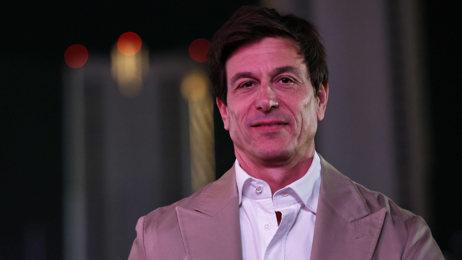 Mercedes boss Toto Wolff smiling in a suit at the Las Vegas Grand Prix.