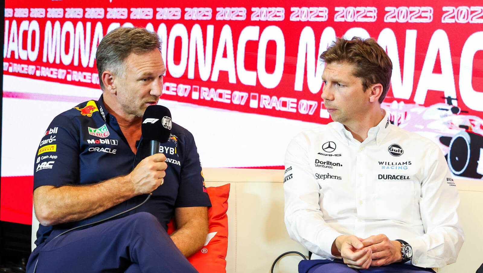 Christian Horner speaking at a press conference, sitting alongside James Vowles.