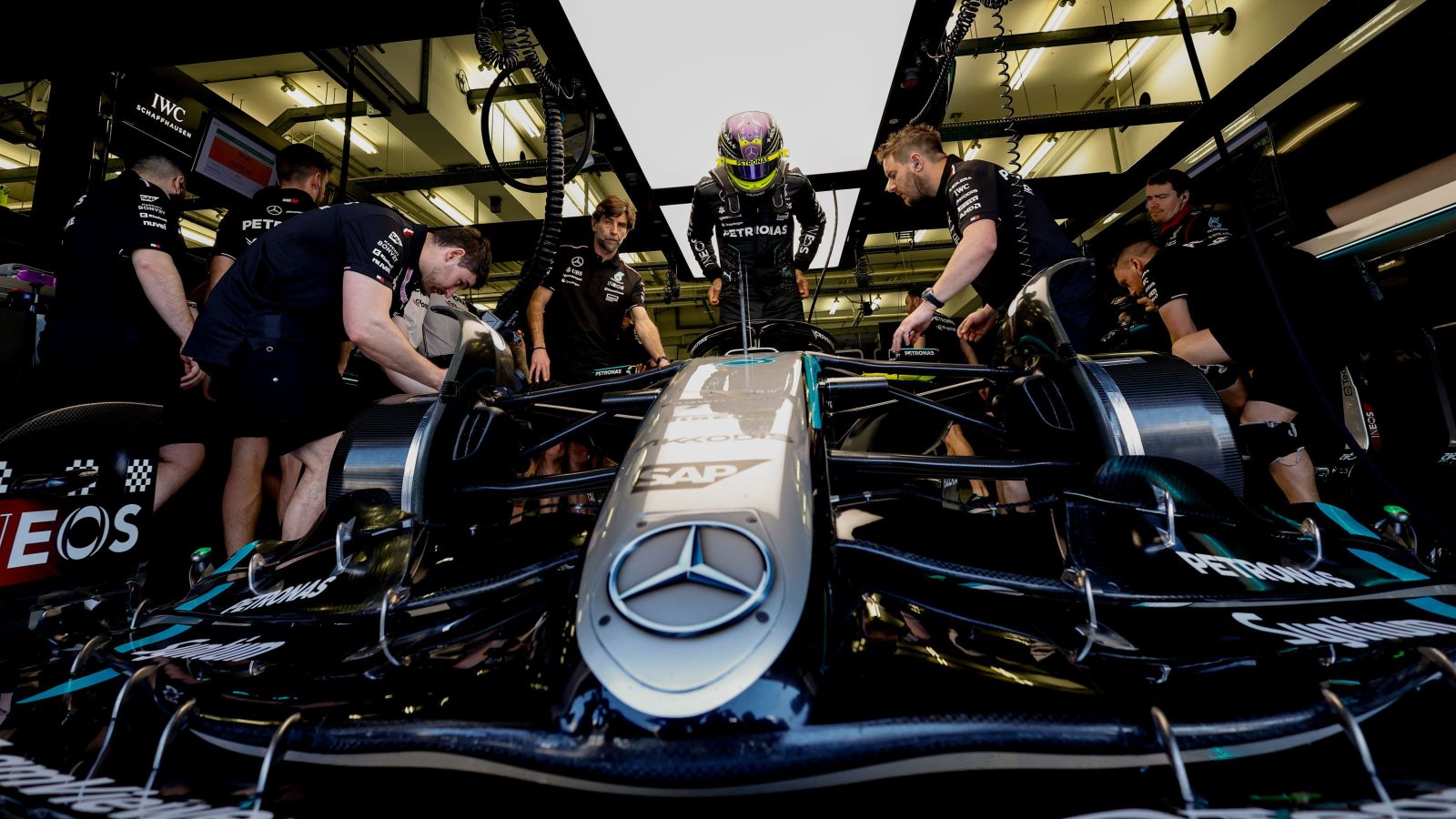 Lewis Hamilton climbs into his W15 in the Mercedes garage during F1 2024 winter testing.