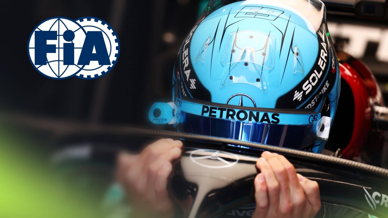 George Russell holds onto the halo as he lowers himself into his Mercedes cockpit with a prominent FIA logo alongside him