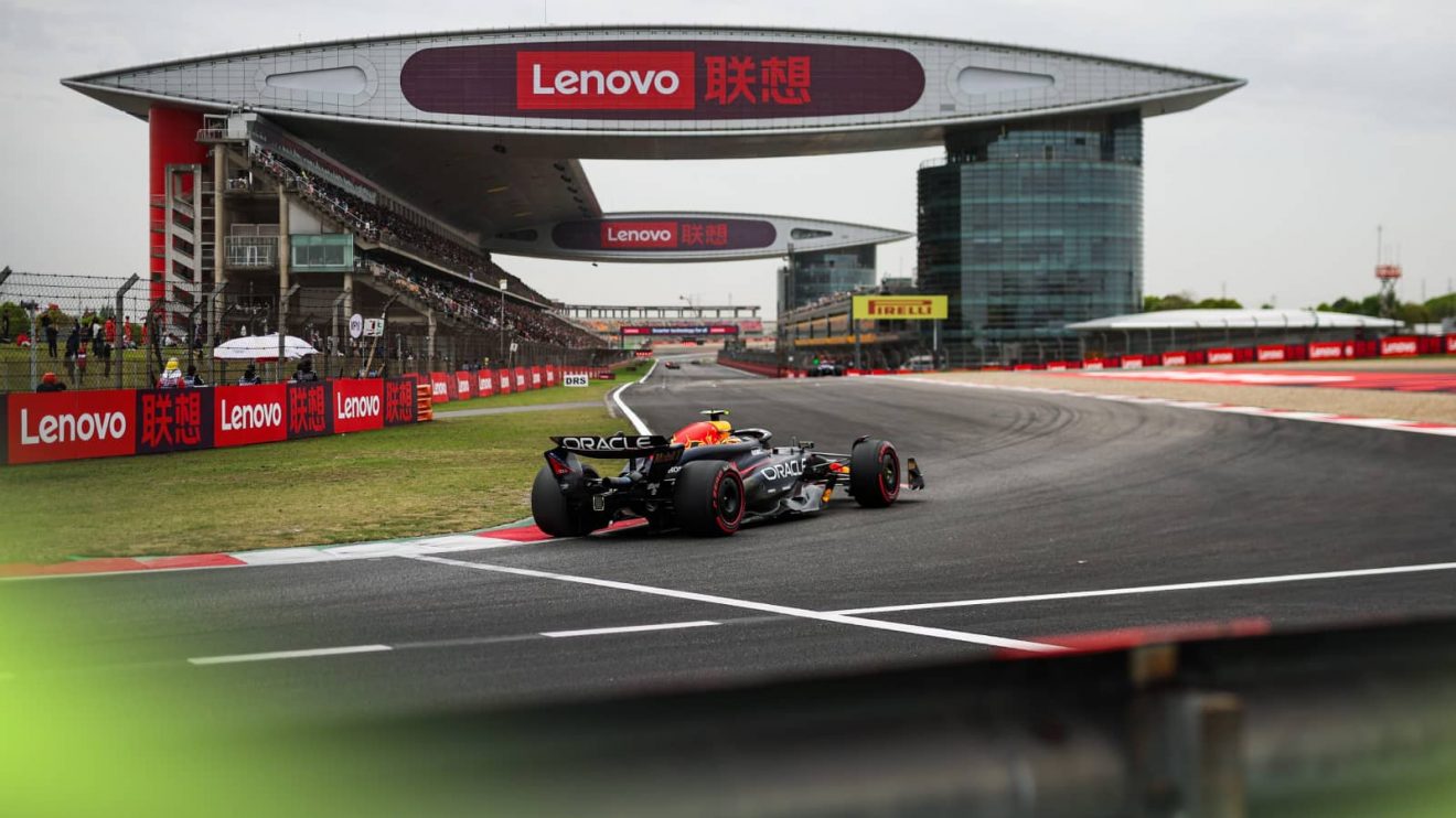 Sergio Perez's Red Bull rounds the final corner in Shanghai with the circuit's impressive pit facility in the background