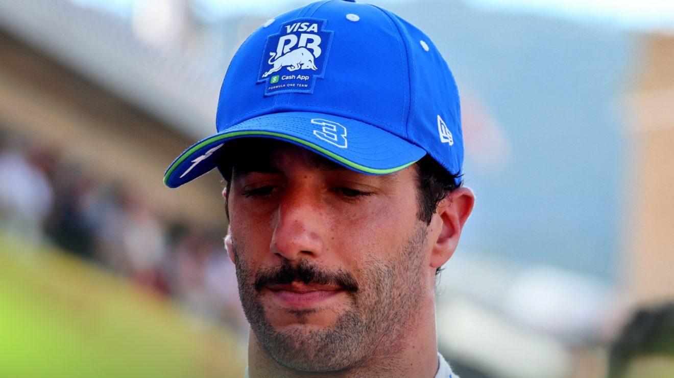 A close-up shot of Daniel Ricciardo looking down as he walks down the pit lane in Monaco