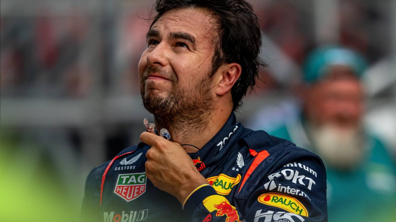 Sergio Perez grimaces as he removes his earplugs