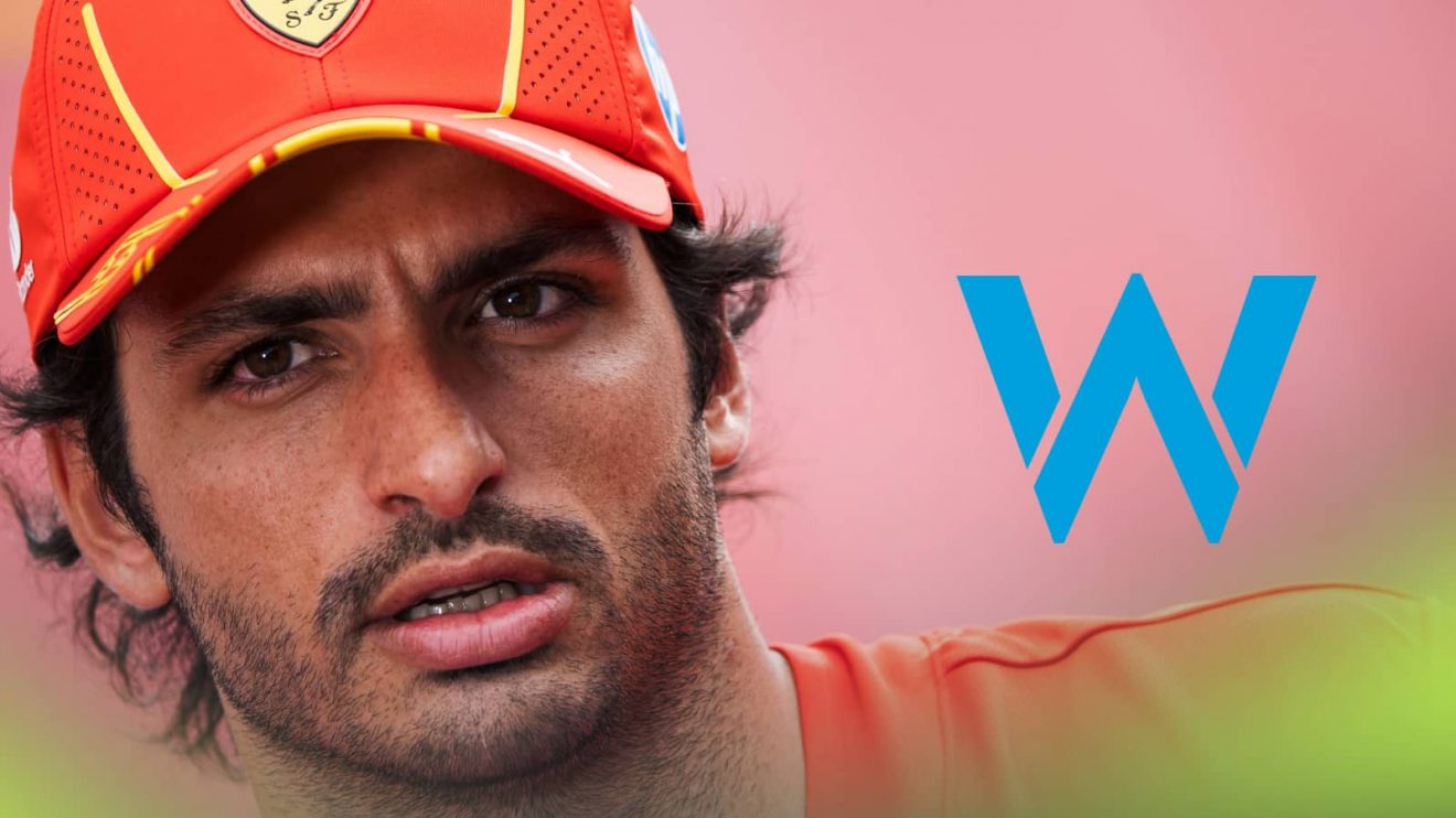 A close-up shot of Carlos Sainz with a prominent Williams logo alongside him