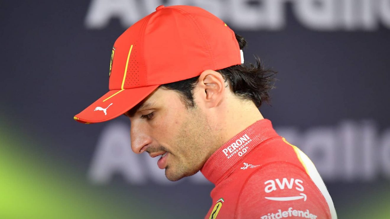 Carlos Sainz looks down as he walks around the TV pen in Melbourne