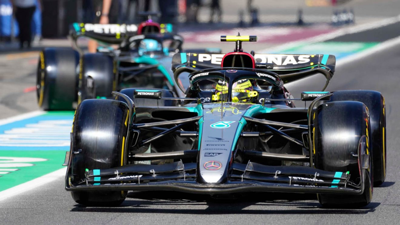 Lewis Hamilton leads George Russell down the pit lane