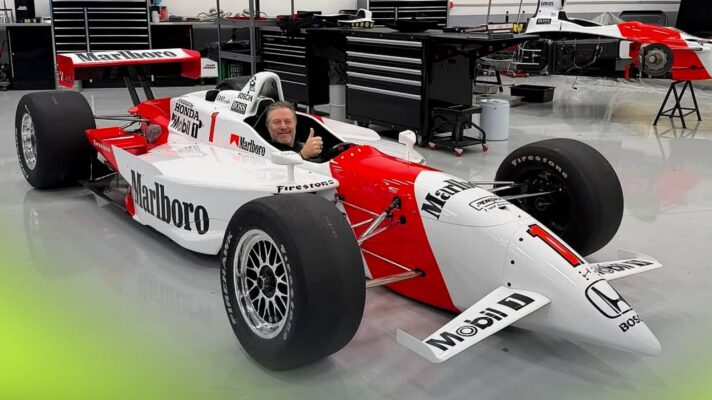 McLaren CEO Zak Brown poses in one of his cars, a 2001 Reynard-Honda run by Penske and driver by Gil De Ferran.