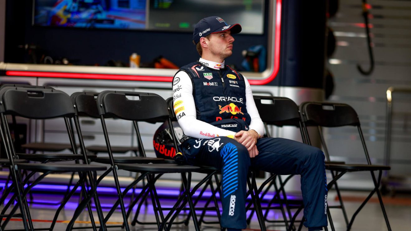 Max Verstappen sitting alone on the pit crew chairs