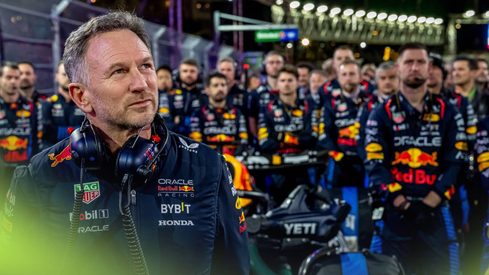 Christian Horner looks to the sky on the grid with a group of Red Bull mechanics behind him