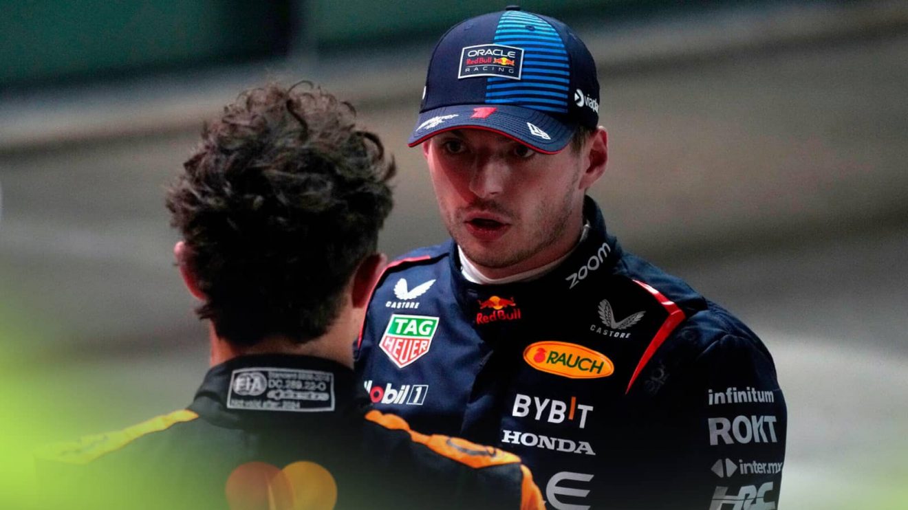 Max Verstappen looks stern in conversation with Lando Norris, whose back is turned to the camera