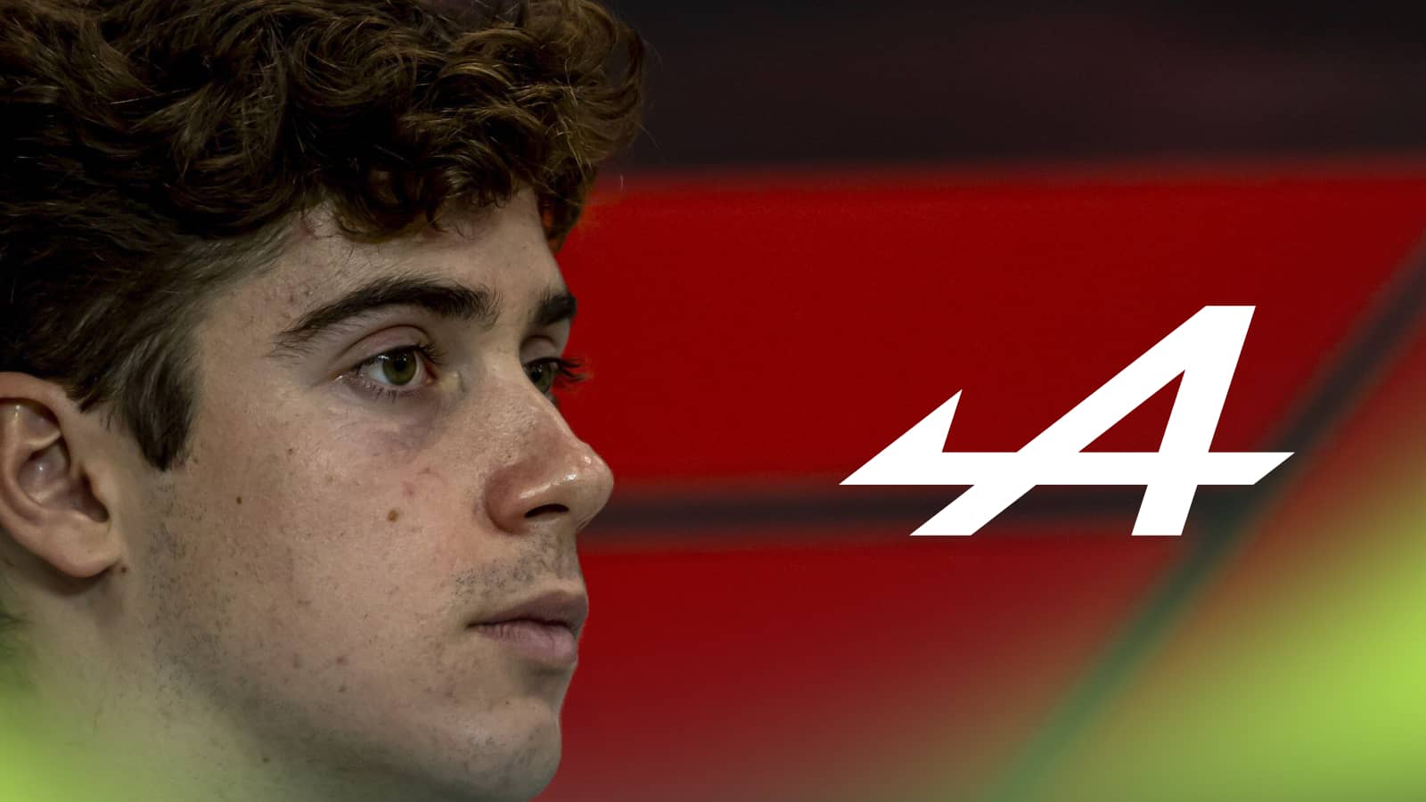 A side-profile shot of Franco Colapinto with a prominent Alpine logo alongside him