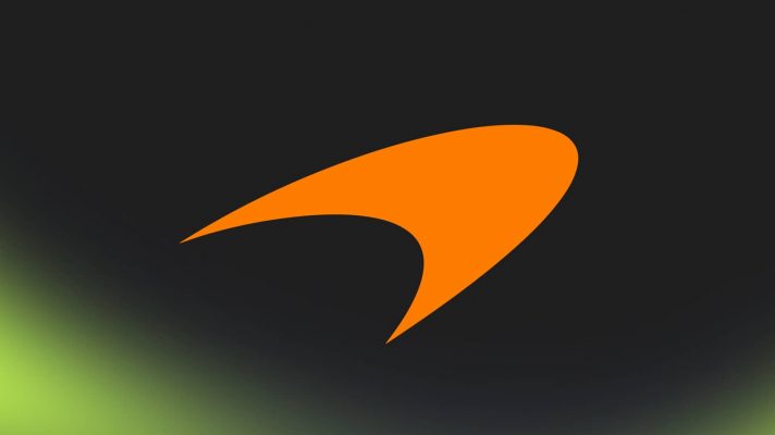 An orange McLaren logo against a black background with PlanetF1.com's lime-green mist along the bottom