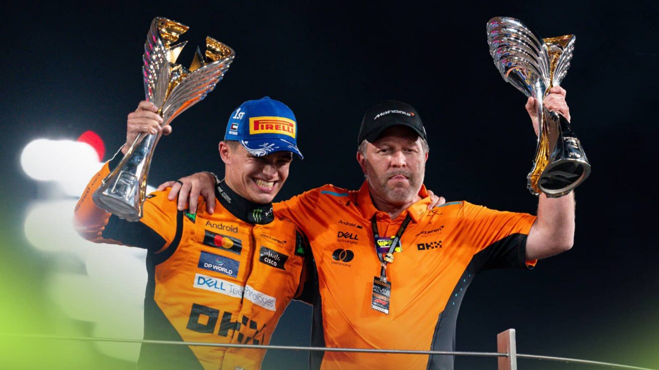 Lando Norris and Zak Brown stand arm in arm as they lift their trophies on the podium in Abu Dhabi