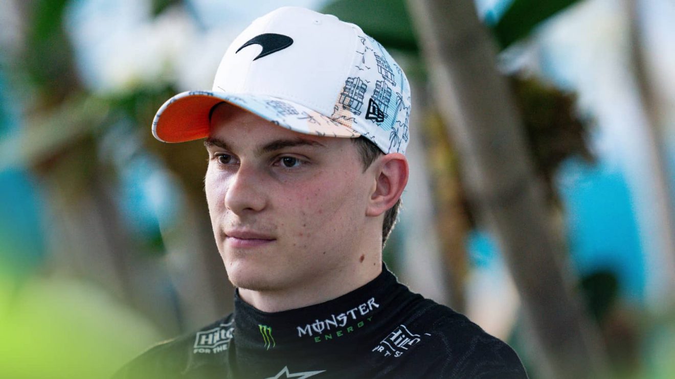 Oscar Piastri looks on in Miami with some palm trees in the background