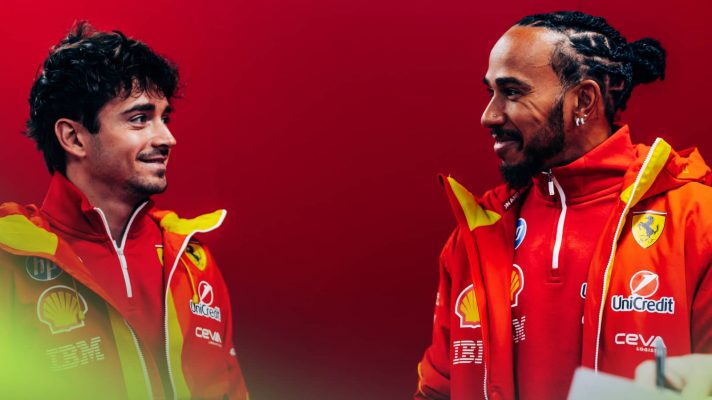 Charles Leclerc and Lewis Hamilton smile at each other in the Ferrari garage