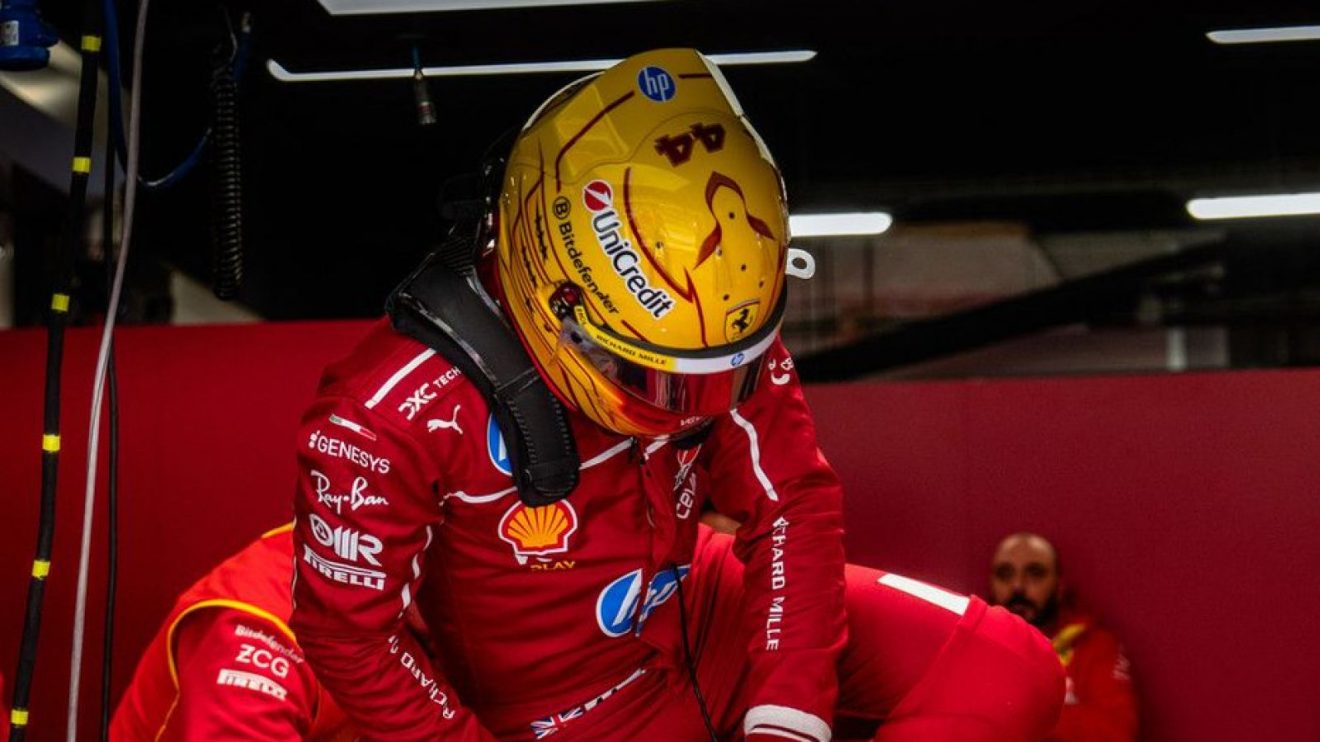 Lewis Hamilton lowers his head as he climbs out of the cockpit in the Ferrari garage