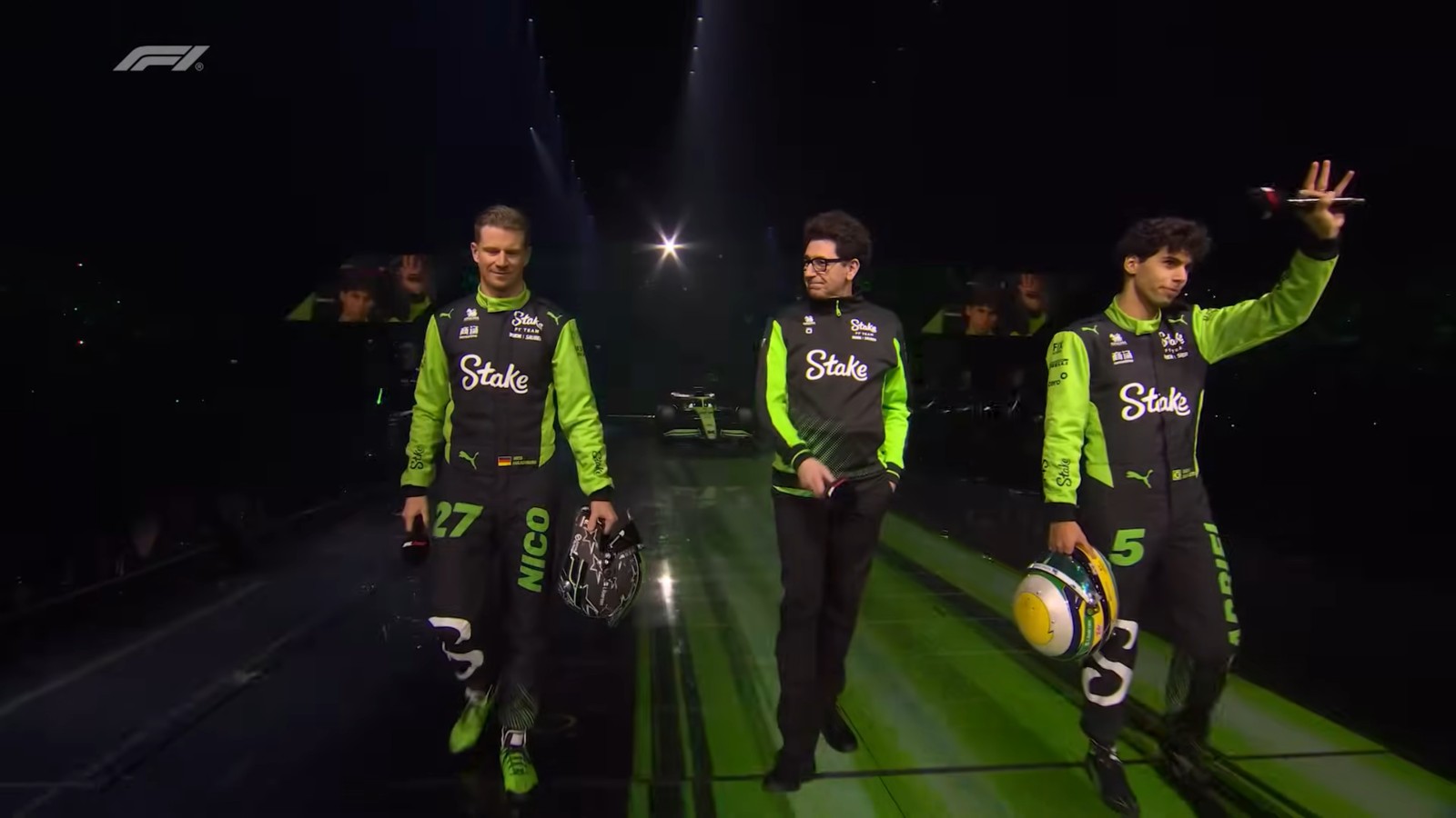 The Sauber drivers carry their F1 2025 helmets on stage.