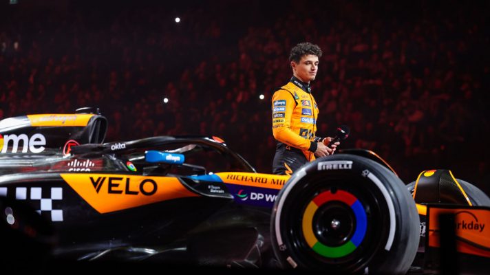 Lando Norris stands next to the McLaren at the F1 75 event
