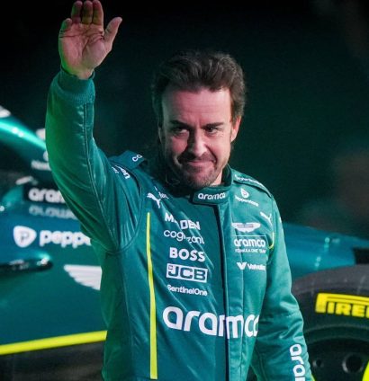 Aston Martin driver Fernando Alonso waves while stood in front of the AMR25 livery on display at the F1 75 season launch event in London